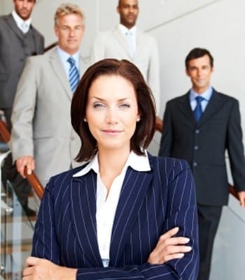 Successful young business woman with her colleagues at the back